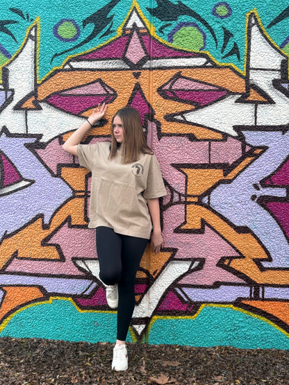 Person posing in front of a colorful geometric mural in taggedstreetwear tee